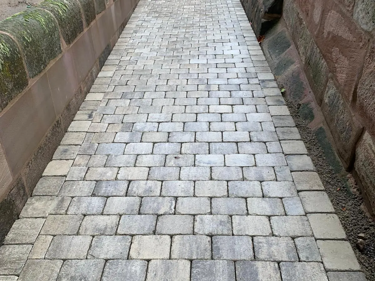 Kopfsteinpflaster-Weg zwischen zwei Sandsteinmauern