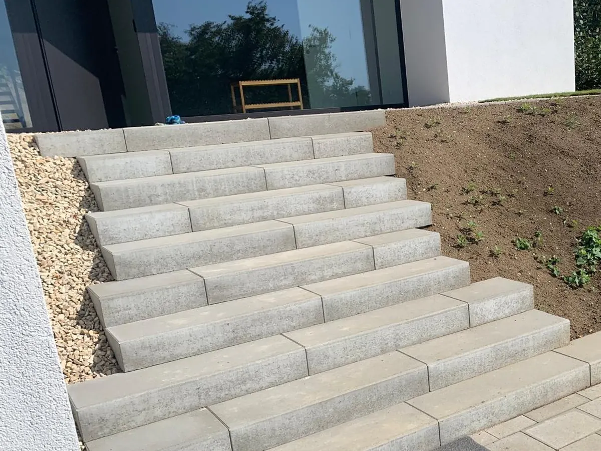 Treppe aus Blockstufen mit gepflasterter Fläche